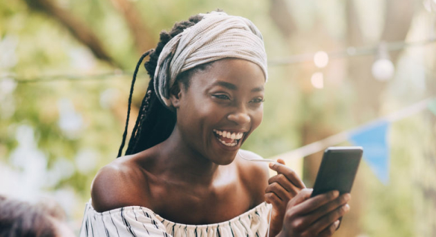 Beatiful black woman holding a phone and smiling